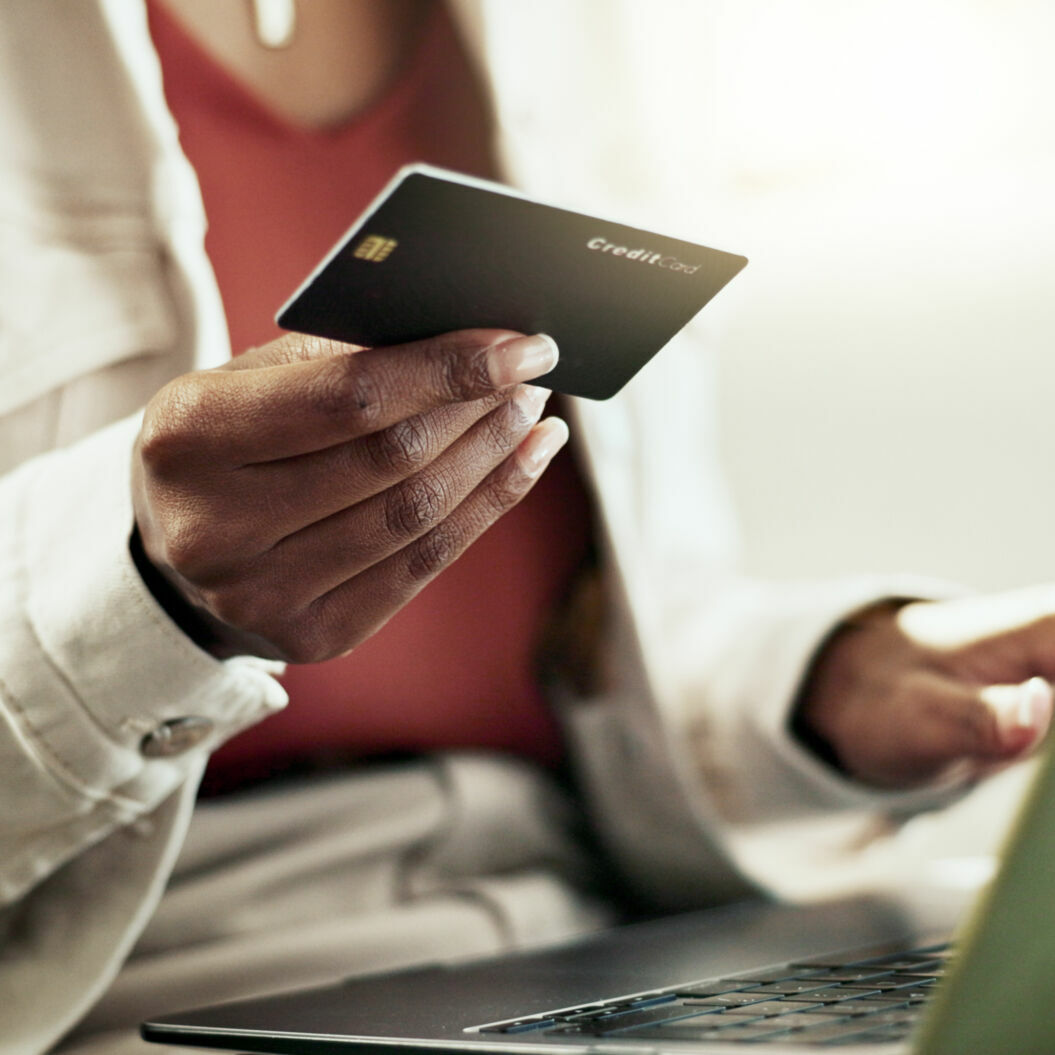 Hands, home and woman with laptop, credit card and ecommerce with savings, investment and payment. Apartment, person and girl on couch, pc and online shopping with budget, closeup and transactions